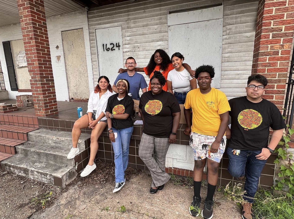 SBCLT Staff outside of one of the Hazel Street homes we are renovating. several are wearing Black SBCLT T-Shirts.